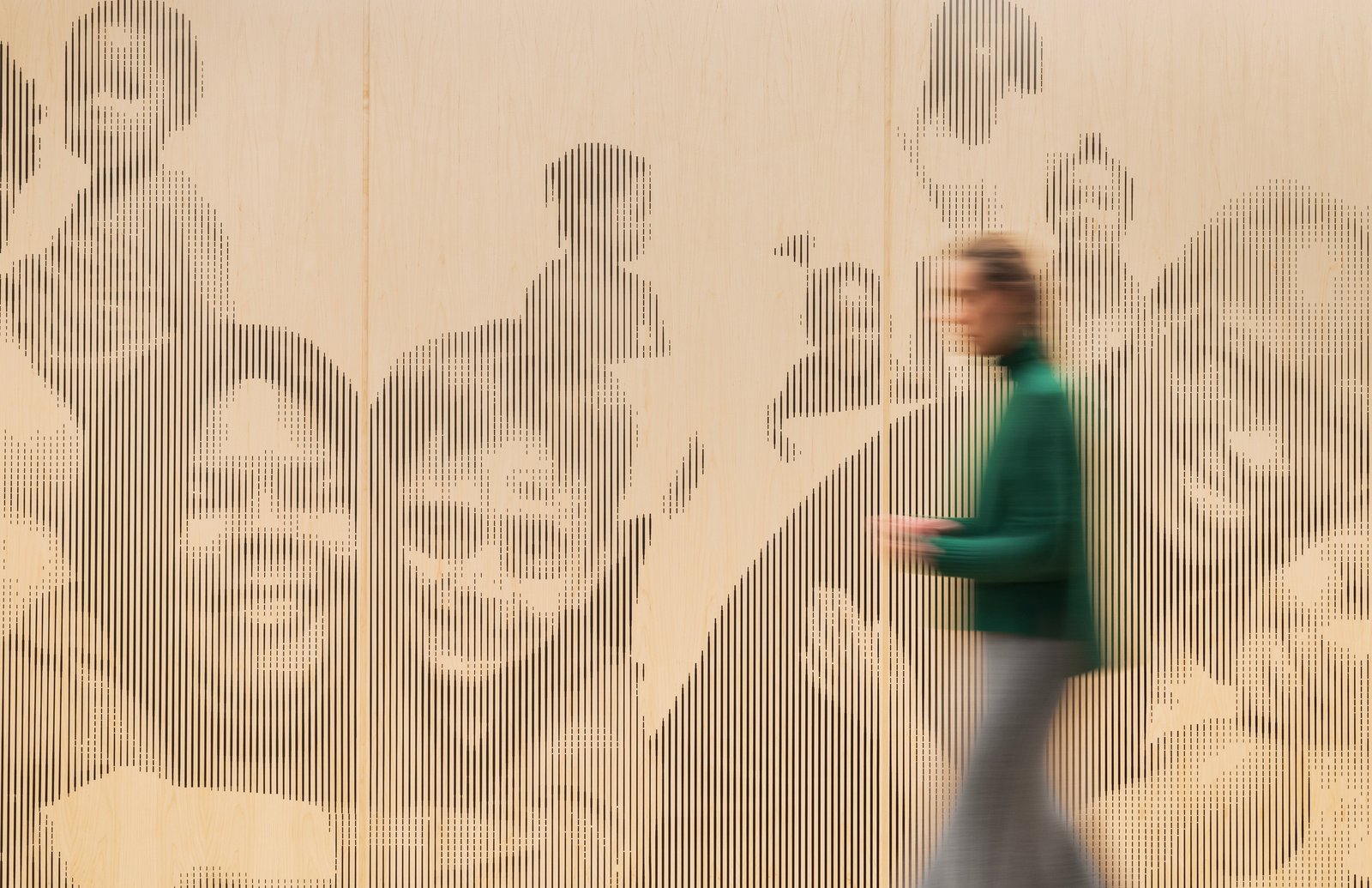 Blurred person walking past wall art depicting families in a therapeutic setting.