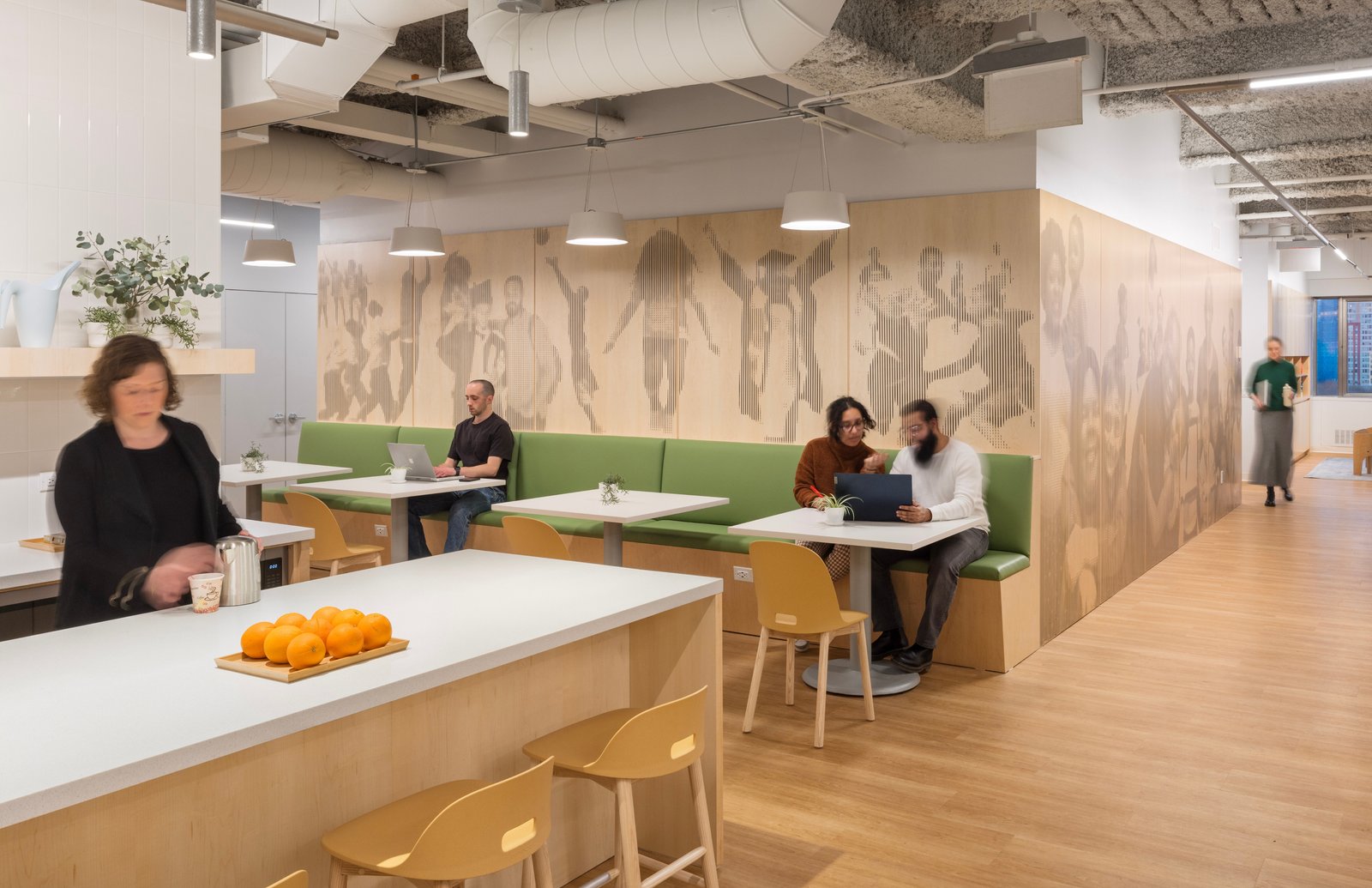 Collaborative lounge area with green booths and wood accents in a therapeutic setting.