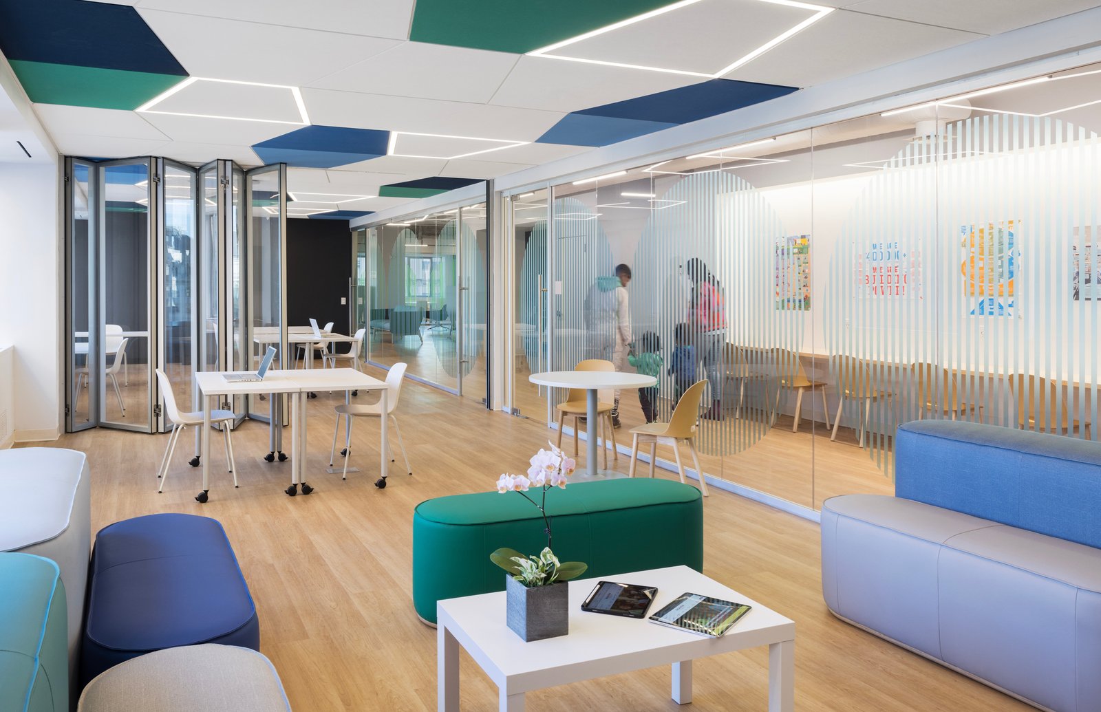 Flexible workspace with colorful ceiling accents and movable partitions.