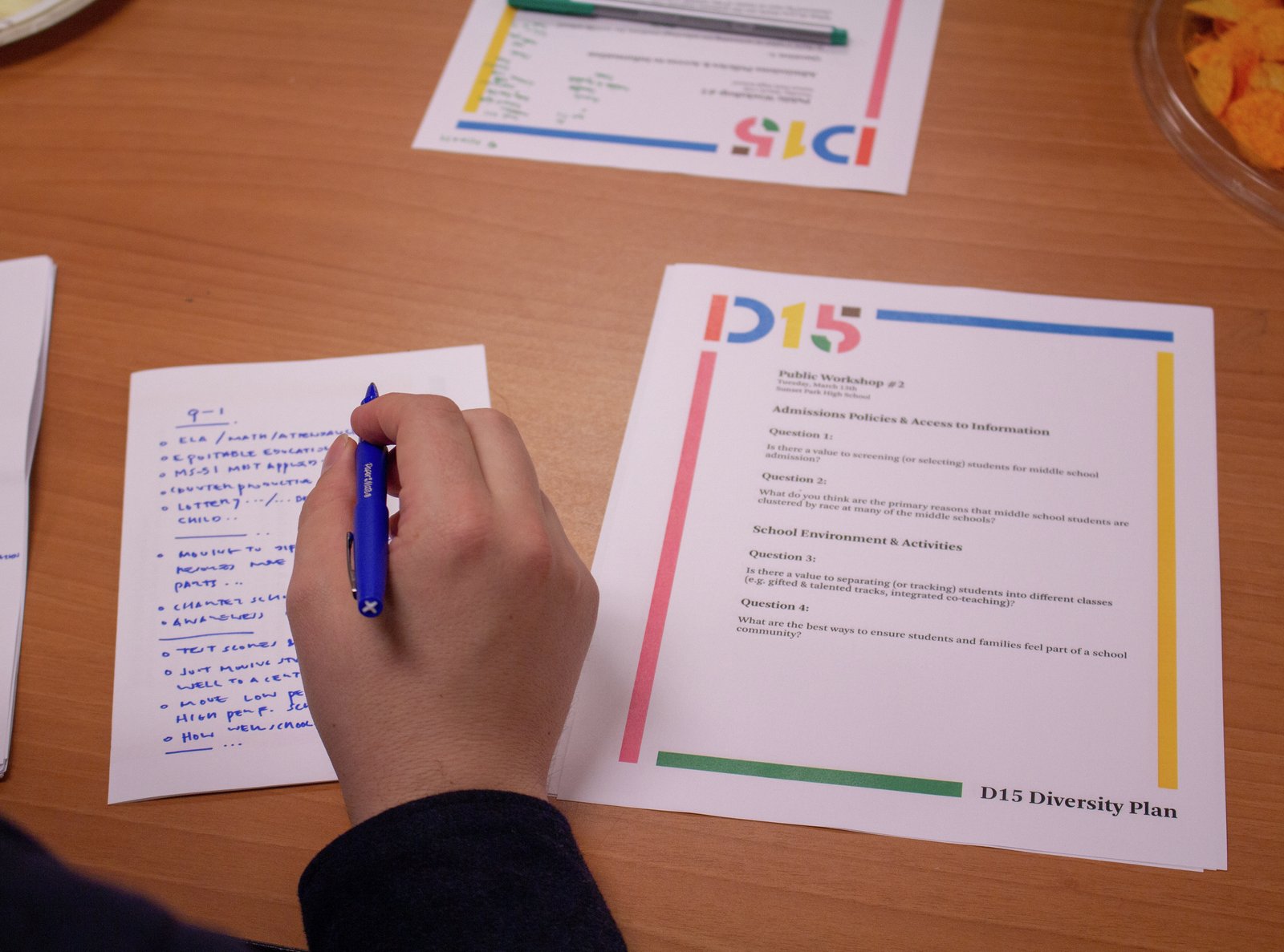 A participant uses a blue pen to take notes on the D15 plan.